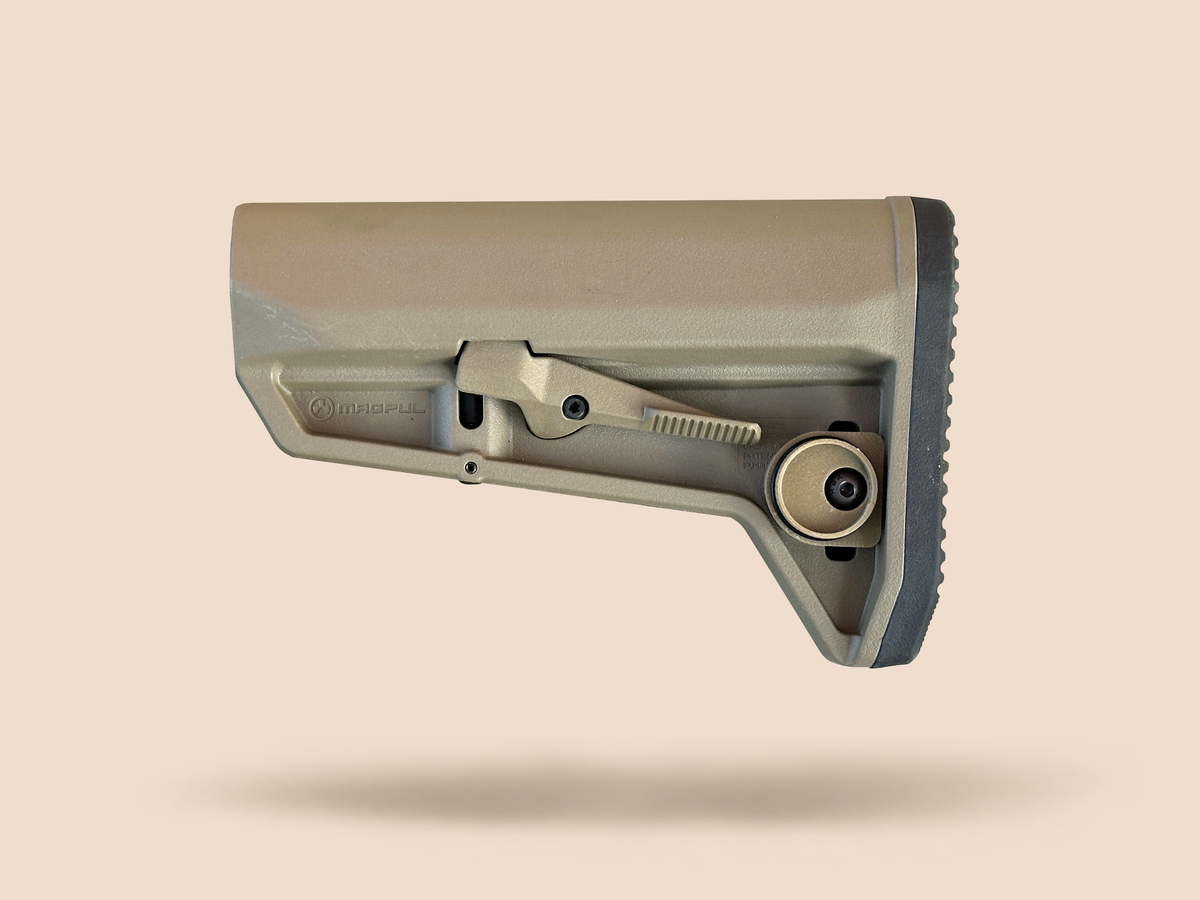CHIP battery holder open and empty on a tan rifle stock, showing the housing and screw